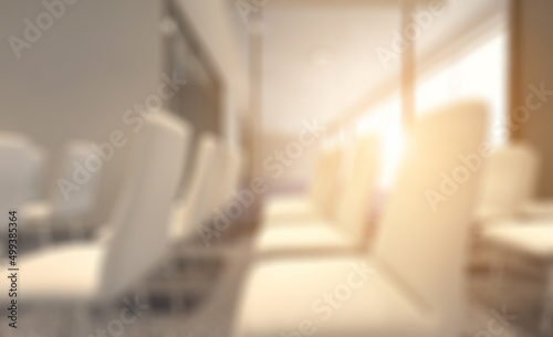 Front view of an office interior with a row of dark wood tables.. Abstract blur phototography.