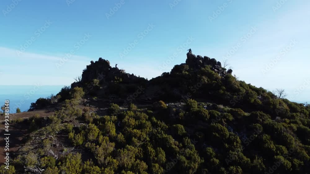 Flight over the slopes of the highest mountain in Madeira, Pico Ruivo. Flying over the rock where two young adventurers look out over the Atlantic Ocean and the valley of the island. Aerial view
