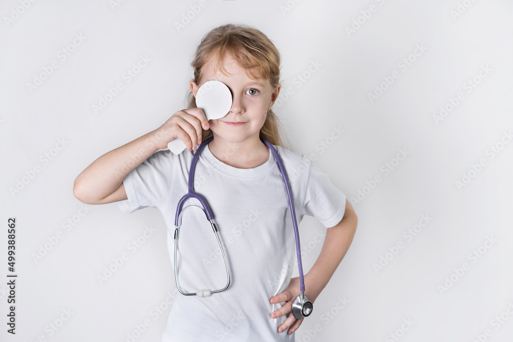 a little girl doctor smiles with a stethoscope and a eye flap, vision check. white background. health check concept a little girl doctor smiles with a stethoscope and a eye flap, vision check. white background. health check concept