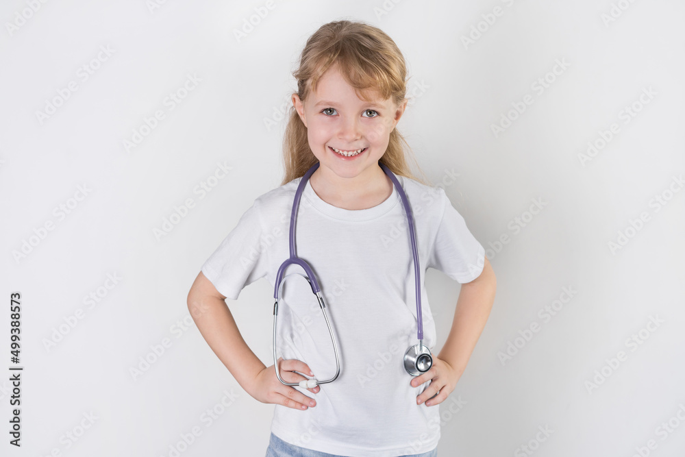 a little girl doctor smiles with a stethoscope. white background. health check concept