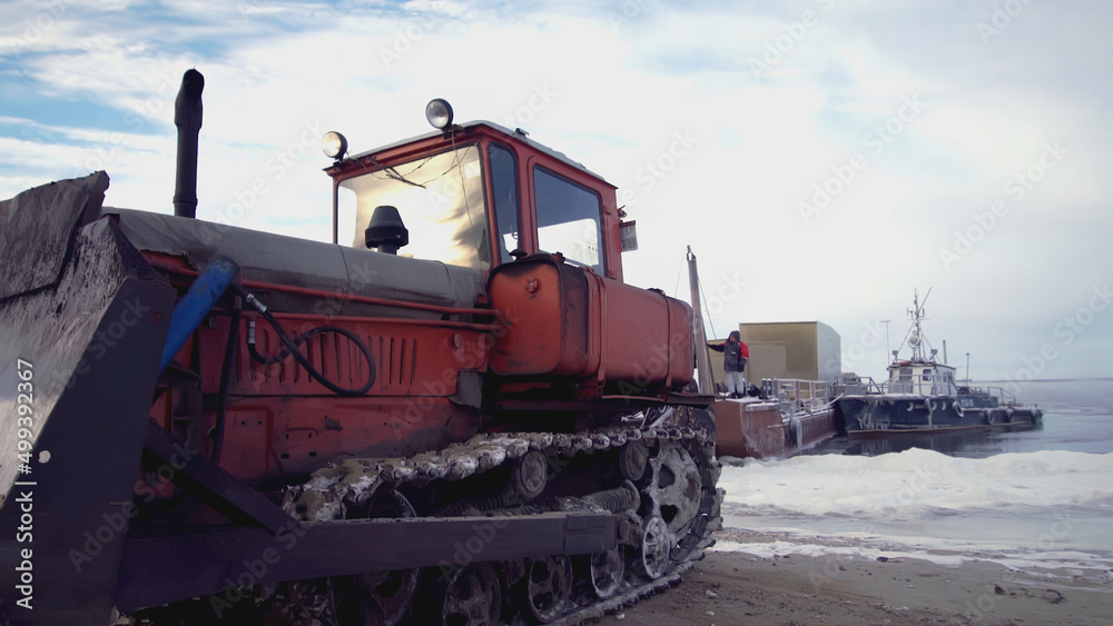 The bulldozer pulls something out with a bucket. CLIP. Close-up on the wheels and bucket of a yellow escalator. In the snow, a bulldozer spins its wheels when it pulls something heavy