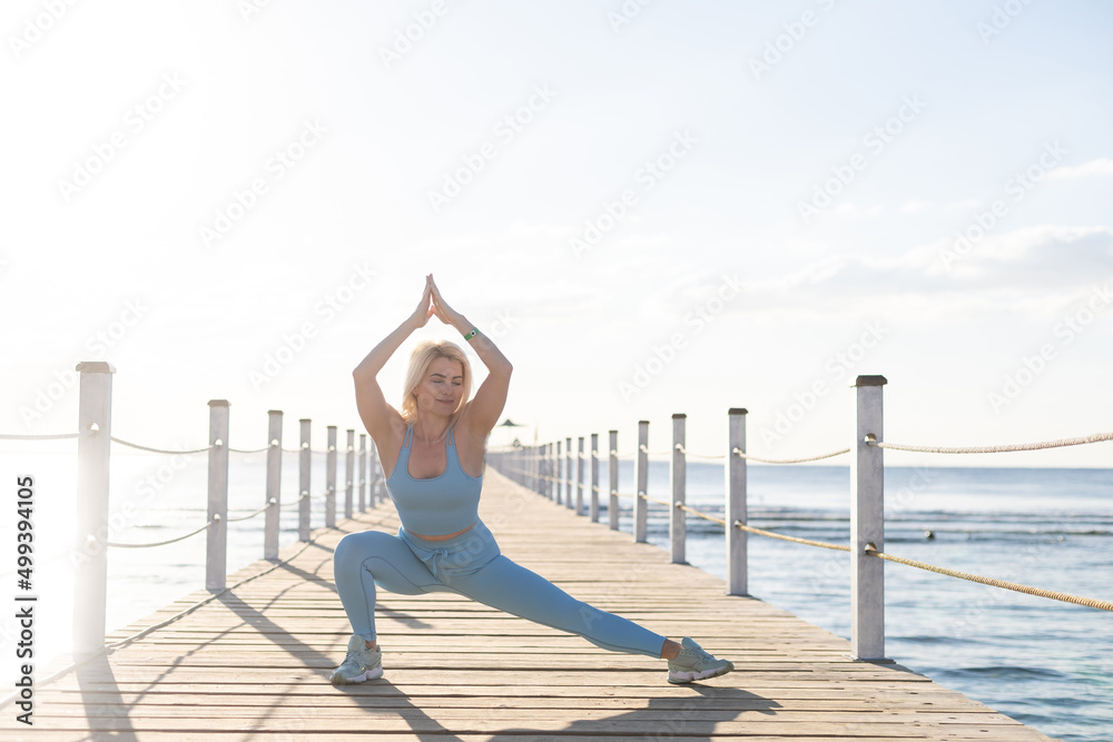 woman exercising on pontoon by the sea