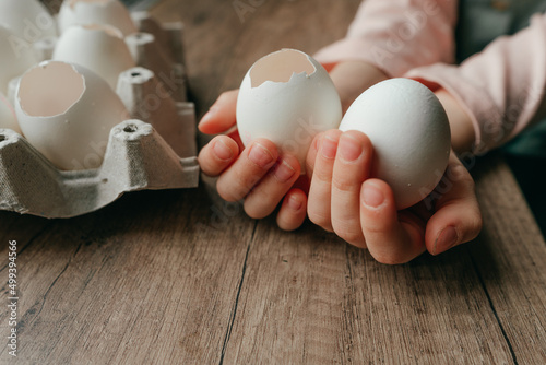 Little girl holding an egg and an empty eggshell in her hands