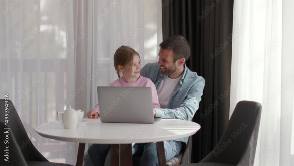 Father and daughter using laptop computer together in the room Father and daughter using laptop computer together in the room