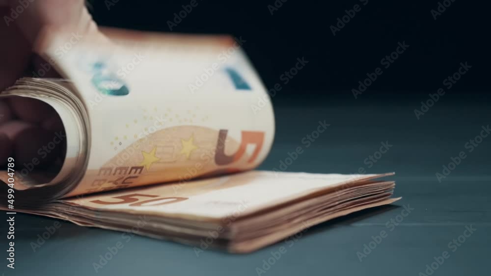 Man counts money. Extreme close-up. Pack of 50 euro banknotes in hands.