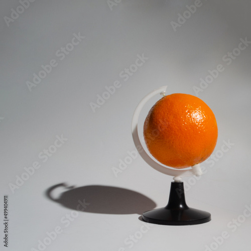 .Orange as a planet of the earth as a globe, on a white background, symbolizes the global trade in this fruit photo