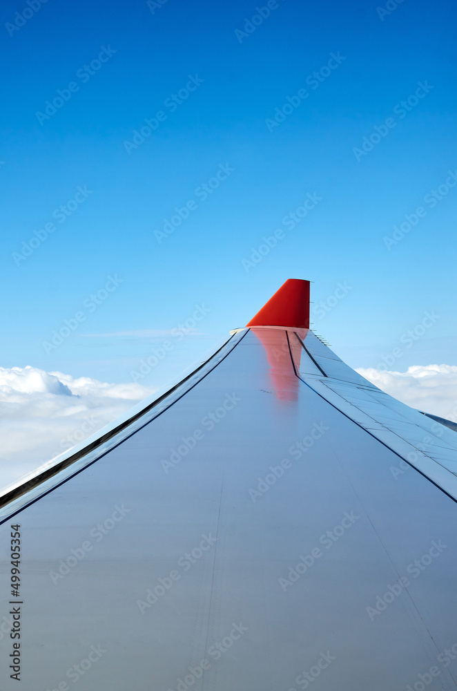 airplane wing in the sky. clear blue sky, white clouds and an airplane wing in the window
