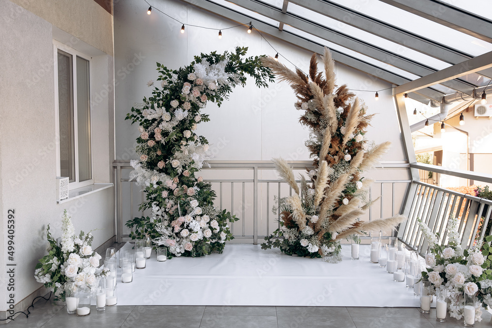 Luxury wedding arch at a banquet in the style of boho. Live plants and decorative light