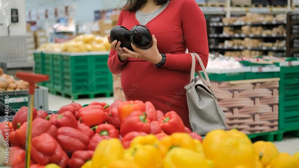 Pregnant Woman Buying Vegetables at Grocery Store, Choosing Eggplants