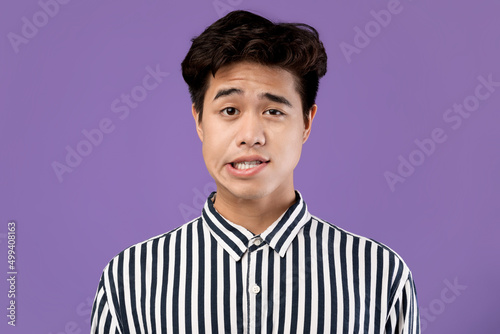 Tableau sur toile Portrait of young Asian man posing grimacing at studio