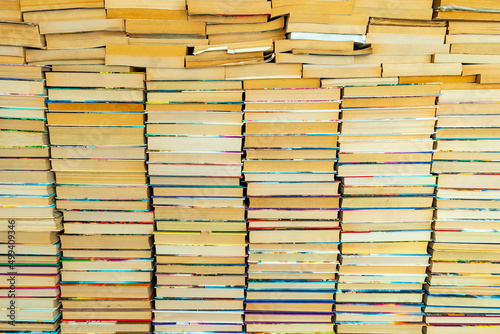 Endless wall of old books stack background. Colorful educational used books folded in many pile columns. Collecting in the library and how to choose only one book horizontal