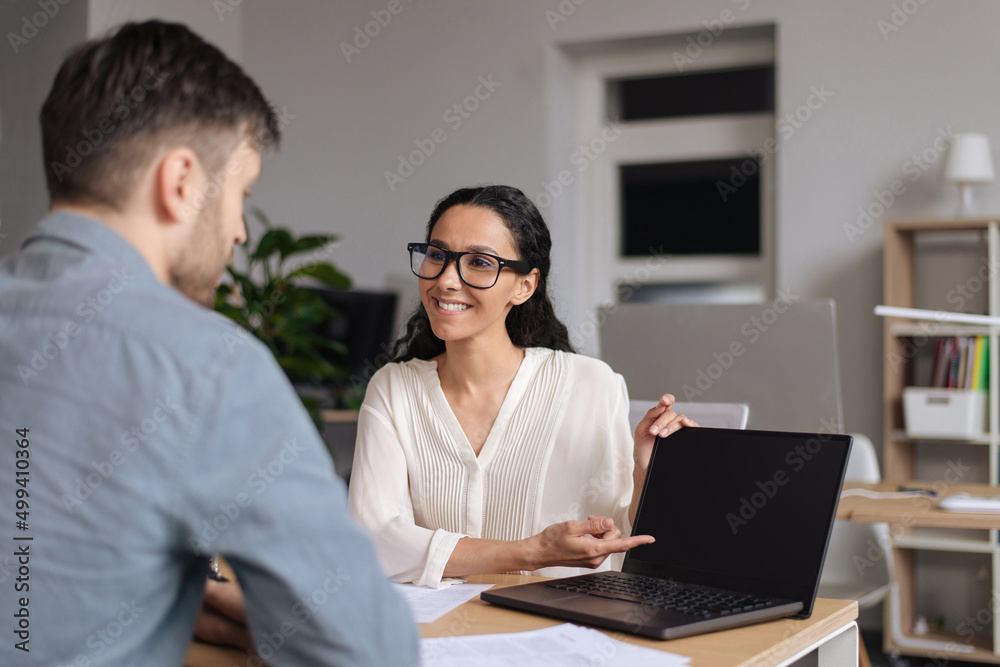 Happy millennial colleagues working together on online business project, using computer with mockup at office Happy millennial colleagues working together on online business project, using computer with mockup at office