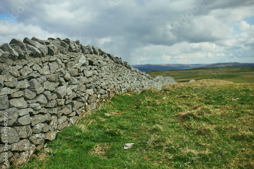 The Peak District National Park, overlooking a winding stone fence through green hills