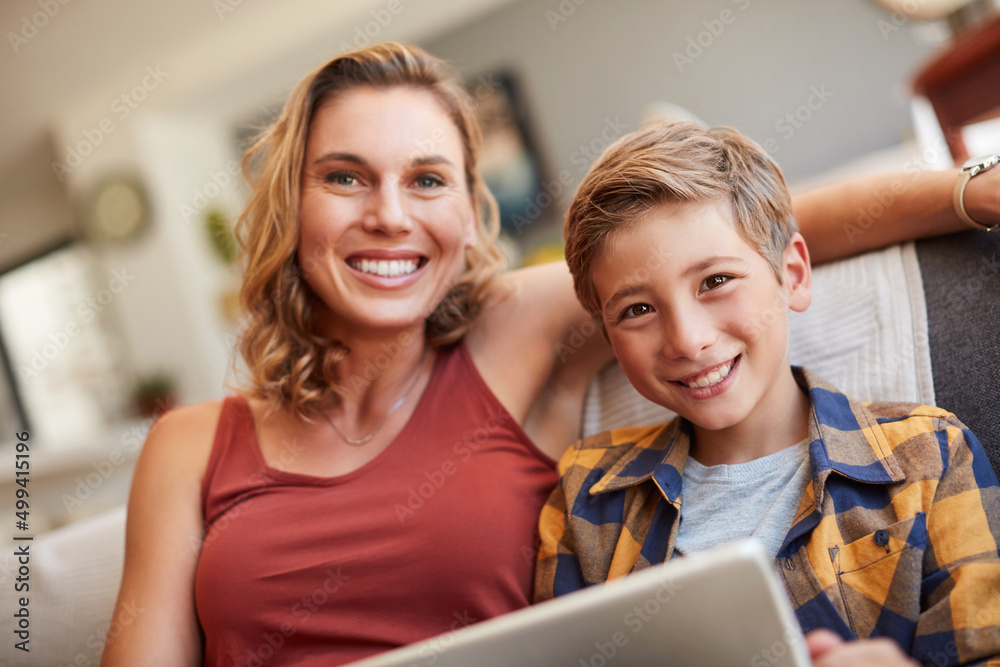 Moms teaching me so much about technology. Shot of an adorable little boy using a digital tablet with his mother on the sofa at home. Moms teaching me so much about technology. Shot of an adorable little boy using a digital tablet with his mother on the sofa at home.