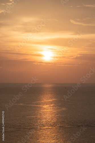Sunset on the sea and through the clouds over. Tranquil seascape with the horizonal skyline.
