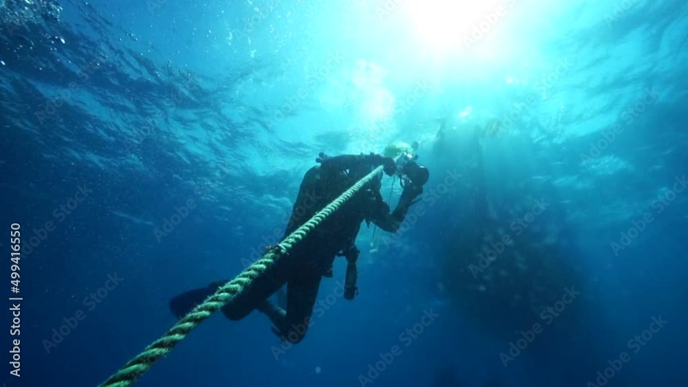 Image of photographer divers climbing aboard a rope underwater. Stock ...