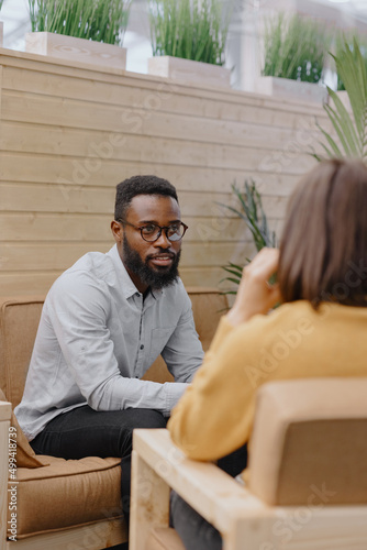 a male psychologist conducts a patient's appointment in an office or a medical center. African American male HR conducts an interview of hiring a European woman. business meeting or solving work tasks