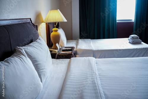 Towels and bedding on double beds in dormitories or guesthouse rooms that are empty.