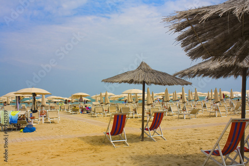 Beach with umbrellas and sun beds on coast in Pesaro  Italy