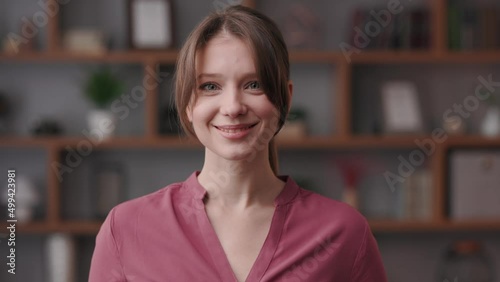 Portrait of smiling beautiful woman looking at camera. Front close up portrait of Caucasian young woman spending time at home. Human face.