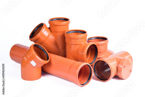 Plumbing fixtures and orange piping parts plastic fittings isolated on a white background