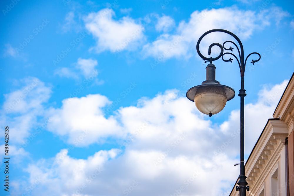 Beautiful forged lantern in the old city against the blue sky Beautiful forged lantern in the old city against the blue sky