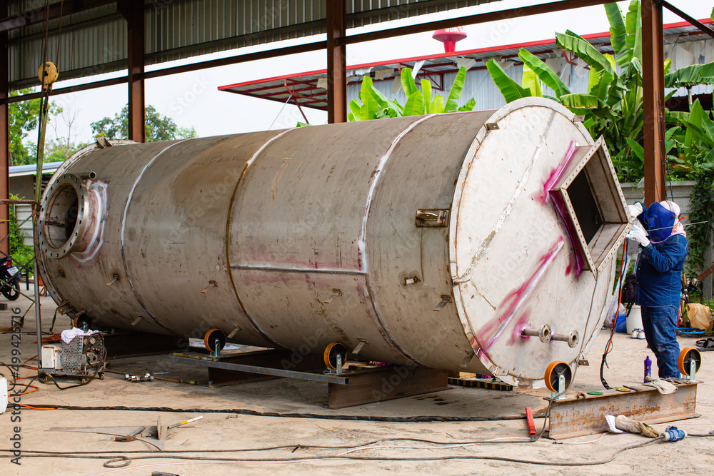 Welding arc argon worker male repaired metal is welding sparks industrial construction tank Welding arc argon worker male repaired metal is welding sparks industrial construction tank