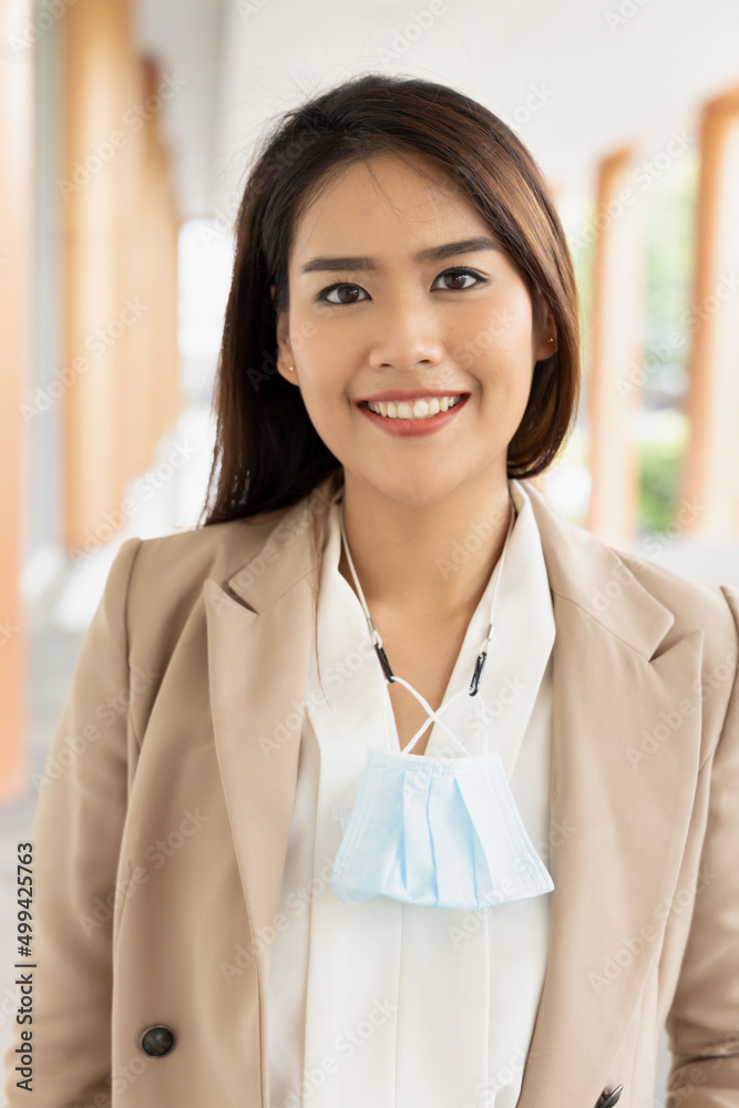 Happy smiling ffice worker going to work with removed face mask but still having mask as precaution Happy smiling ffice worker going to work with removed face mask but still having mask as precaution