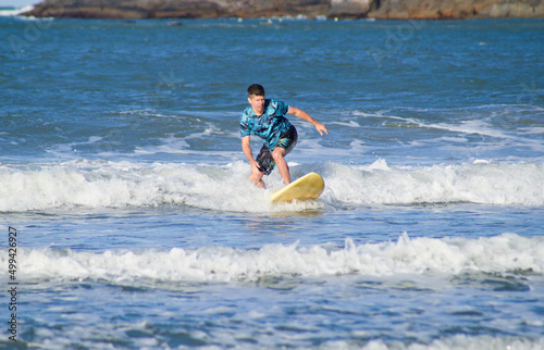 Beginner surfer on a small wave at matadeiro beach, Florianópolis, Brazil © felipecamps