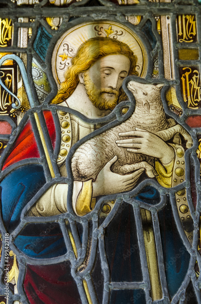 Stained glass window showing Jesus holding a lamb