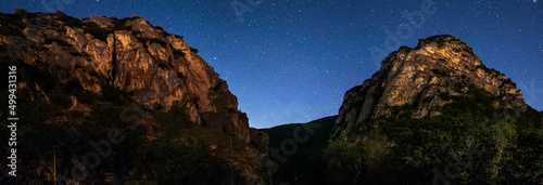Night starry sky at rock cliffs landscape in Marche region, Italy. Unique canyon and river gorge, scenic hill and mountain landscape.