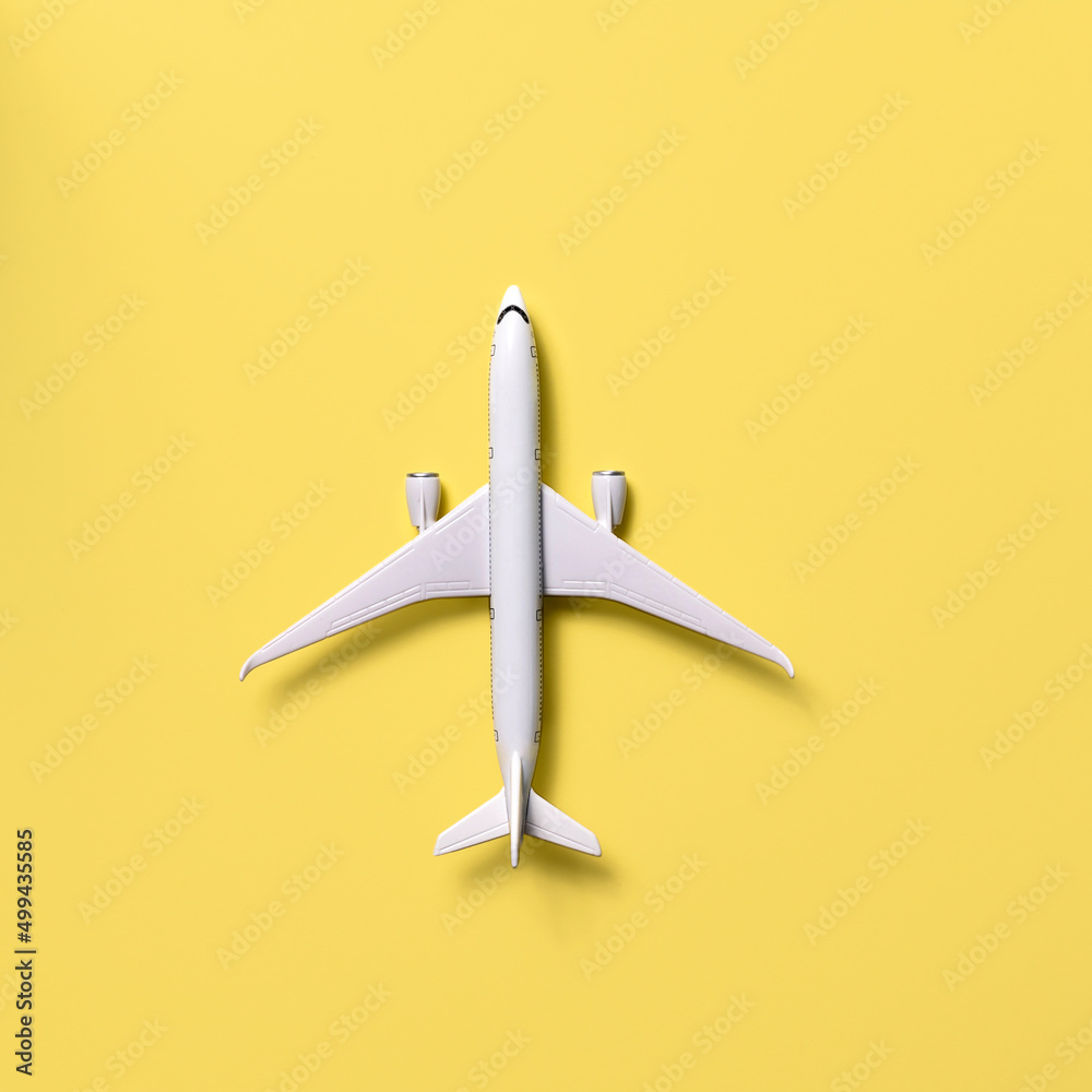 Overhead view of airplane model against yellow background Overhead view of airplane model against yellow background