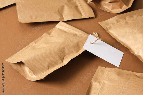 mock up blank paper bags and white cardboard tag on brown background Eco friendly packaging,