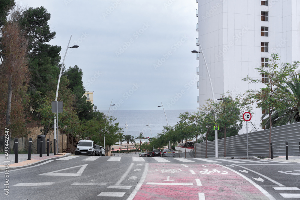 Bike lane on a downhill slope on an avenue in Benidorm, Spain, leading to the beach.
