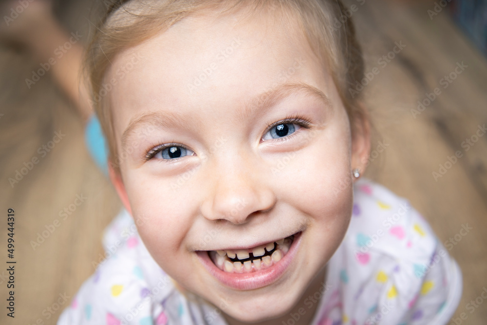 Smiling cute beautiful child girl in t-shirt lying on wooden floor. Smiling cute beautiful child girl in t-shirt lying on wooden floor.