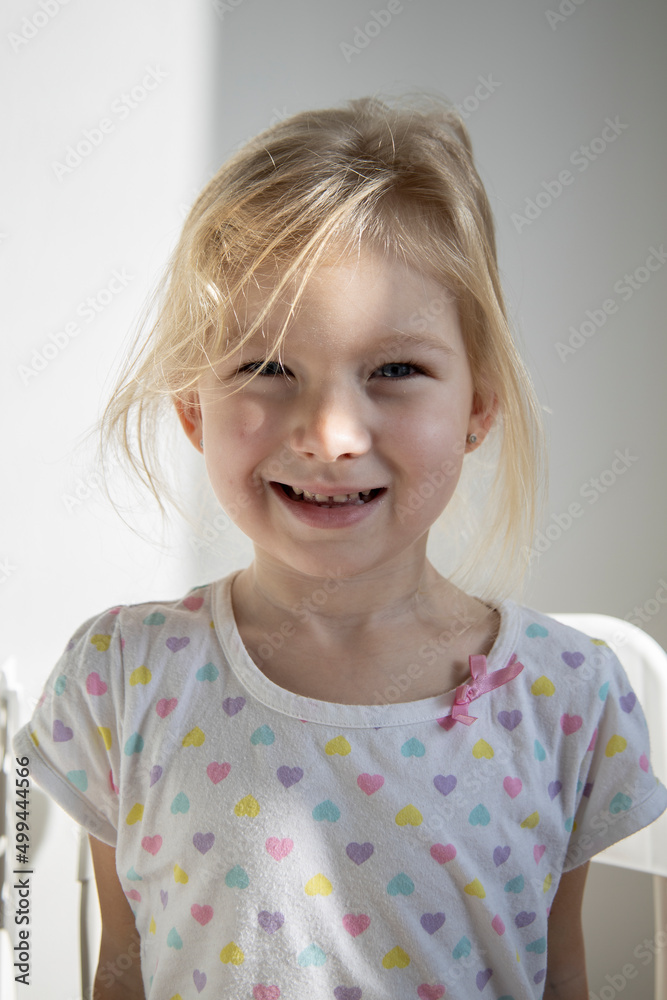 Beautiful smiling child girl blonde on the background of a white wall. Beautiful smiling child girl blonde on the background of a white wall.