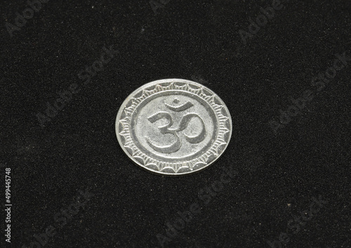 ohm symbol silver metal coin. on a black background photo