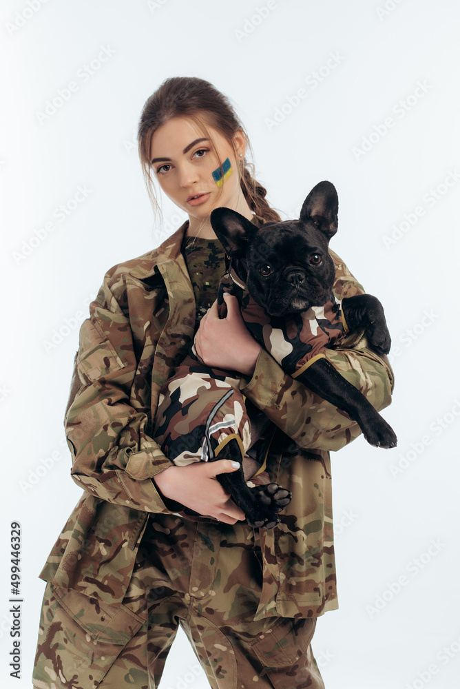A girl in military uniform holds a dog in military uniform in her arms. Ukrainian. War in Ukraine. on a white background A girl in military uniform holds a dog in military uniform in her arms. Ukrainian. War in Ukraine. on a white background