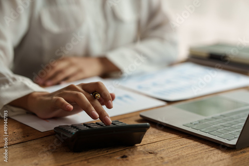 Close up Business woman hand using calculator to calculate the company's financial results and budget. Account Audit Concept.