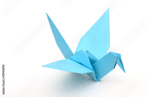 A blue paper bird on white