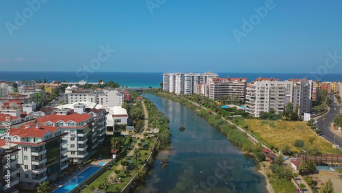 The view from the drone. Clip. View of the blue clear ocean near the resort area with a swimming pool and houses .