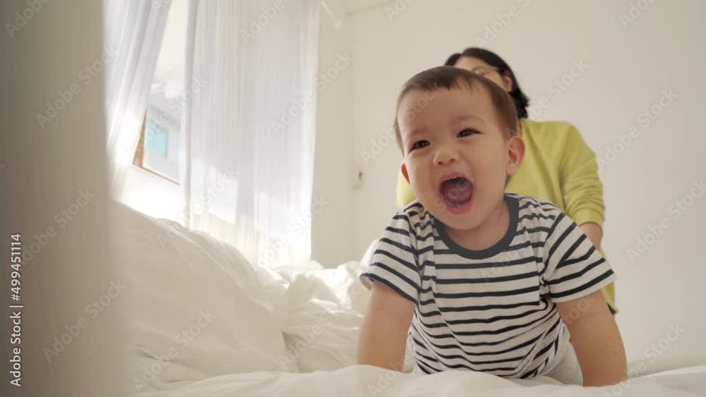 Cheerful Asian mother playing with her adorable cute boy on bed, Happy Family having Fun at home, Laughing, Single Mom. Cheerful Asian mother playing with her adorable cute boy on bed, Happy Family having Fun at home, Laughing, Single Mom.