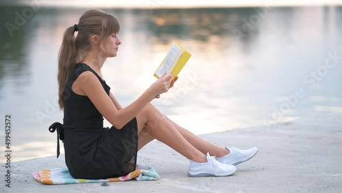 Young woman resting in summer park reading a book. Education and sudy concept photo