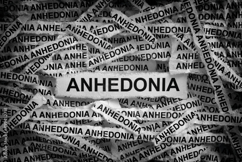 Strips of newspaper with the words Anhedonia. Black and white. Close up. photo