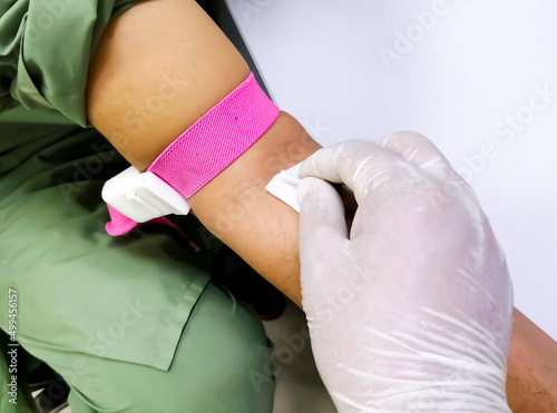 Phlebotomist disinfect blood collection area by alcohol pad.