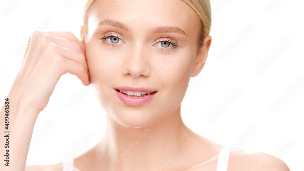 Close-up beauty portrait of young blond Caucasian woman who touches her face looking at camera on white background | Skin hydration concept