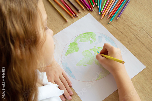 Child girl draws planet for earth day. Protection of enviroment, Save our planet. Concept of art learning and education, love earth , save world and unity.Ecology concept.Selective focus