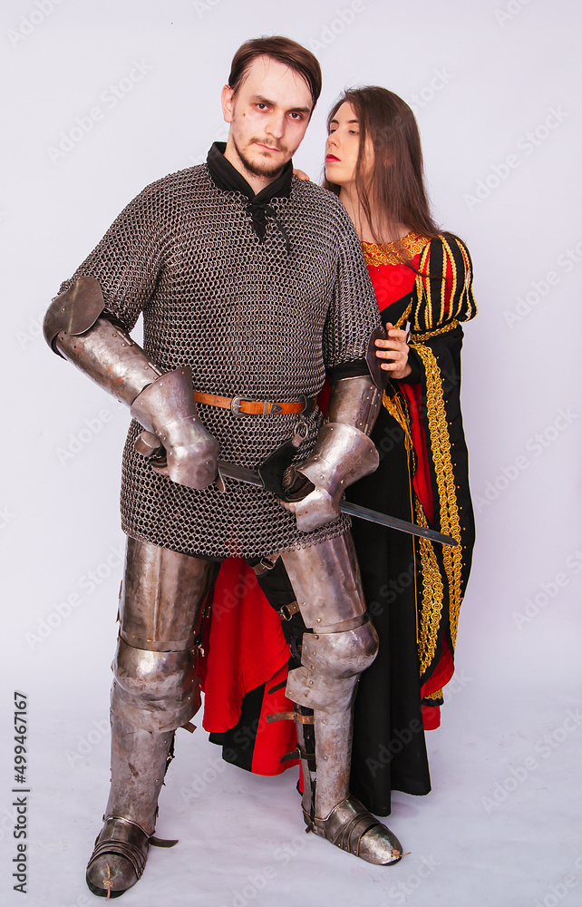 Obraz premium Knight in armor with a sword and a young woman in a medieval black dress. Love story. Married couple. Fantasy illustration for a book novel.
