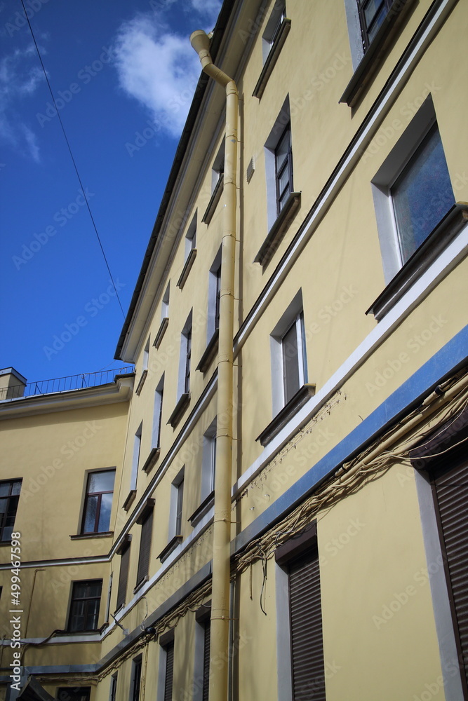 Fototapeta premium Old four-story yellow house in the city center