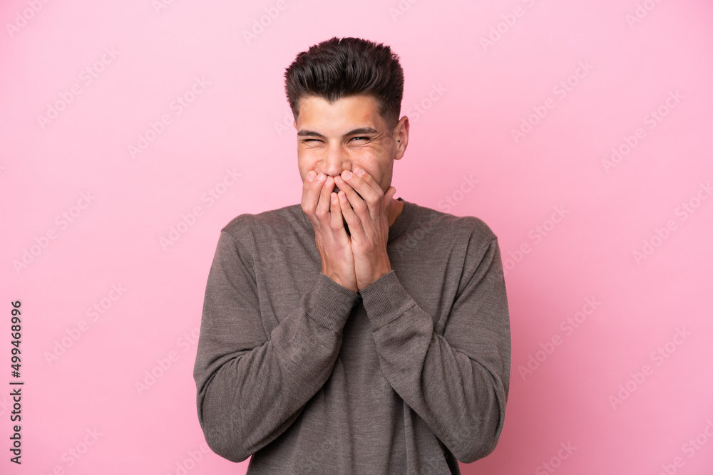 Young caucasian man isolated on pink background happy and smiling covering mouth with hands Young caucasian man isolated on pink background happy and smiling covering mouth with hands